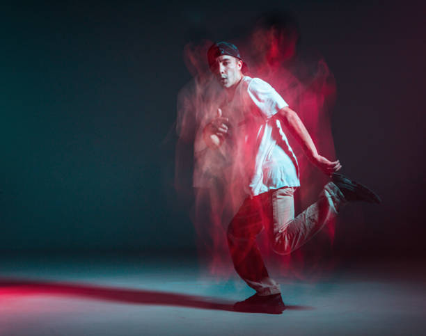 istock Stylish young guy breakdancer dancing hip-hop in neon light. Dance school poster. Long exposure shot 1268661196