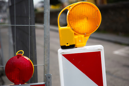 Close-up of red warning lights with street barriers at a construction site
