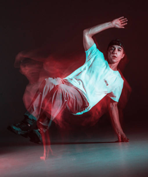 istock Stylish young guy breakdancer dancing hip-hop in neon light. Long exposure shot 1268662488