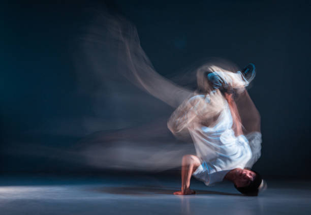 istock Stylish young guy breakdancer dancing hip-hop in neon light.. Long exposure shot. Battle competition announcement 1268663037