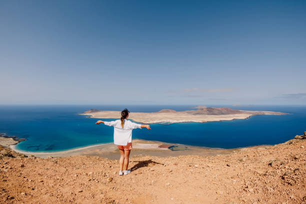 ランサローテ島からラ・グラシオサへの幸せな旅行者の女性と風光明媚な視点 - lanzarote ストックフォトと画像