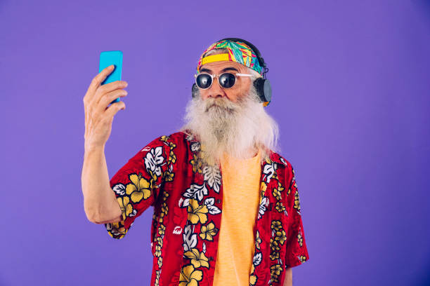 Stylish senior man portrait Senior man with eccentric look  - 60 years old man having fun, portrait on colored background, concepts about youthful senior people and lifestyle irony stock pictures, royalty-free photos & images