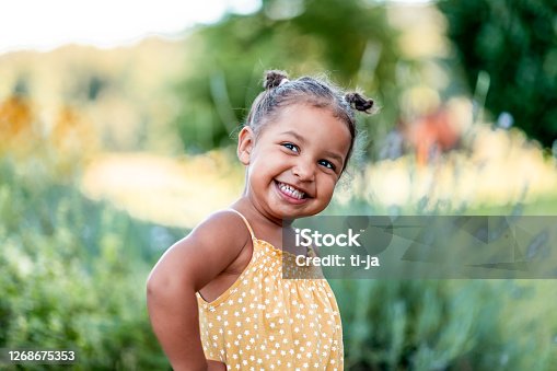 istock Portrait of cute little girl outdoors 1268675353