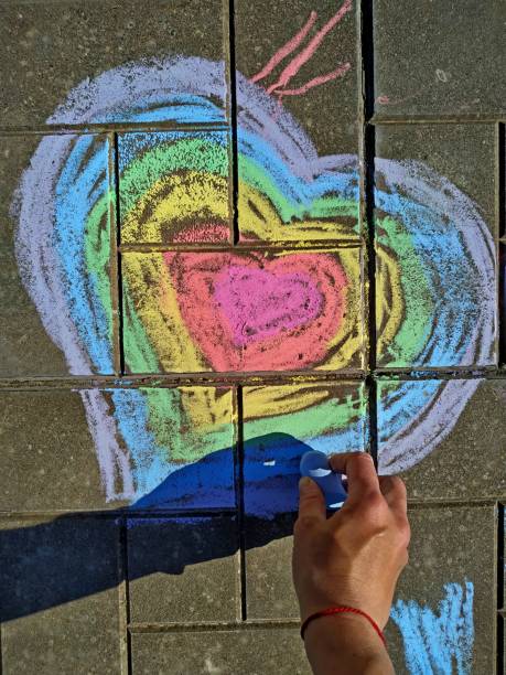 istock female hand draws a rainbow heart on concrete tile on summer day. 1268675703