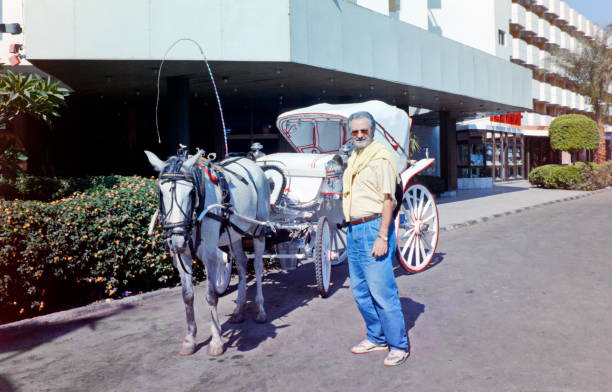 The nineties. A tourist is looking for the horsedrawn driver. Luxor, Upper Egypt.