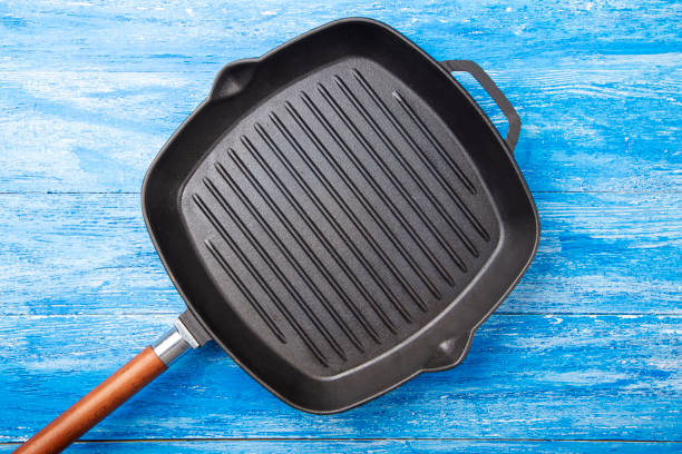 istock Empty cast-iron grill pan on a blue wooden background. 1268680297
