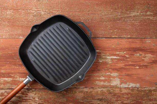 istock Empty cast-iron grill pan on a red wooden background. 1268680324
