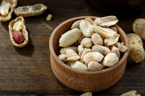 istock Peeled and unpeeled peanuts in a bowl 1268681052