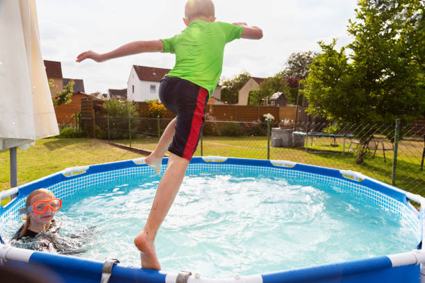 istock Boy and girl playing in pool 1268681500