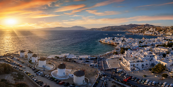 Panoramic aerial view to the beautiful windmills and town of Mykonos during summer sunset time, Cyclades islands, Greece