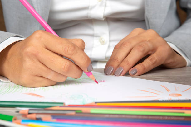 istock woman's hand in the office draws with crayons on paper 1268682876