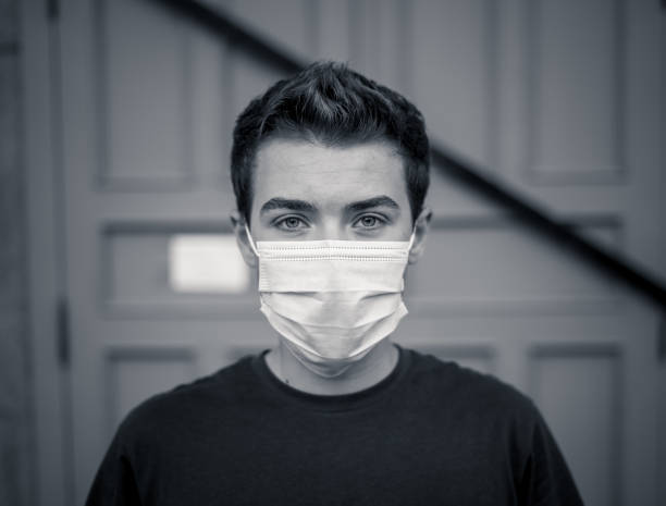 istock Young man wearing medical protective surgical face mask against infectious Coronavirus disease. Conceptual portrait of New Normal and Protection against Covid-19 outbreak. 1268683098