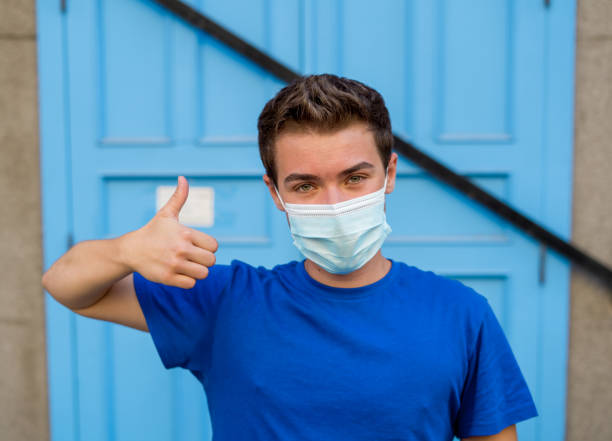 istock Young man wearing medical protective surgical face mask against infectious Coronavirus disease. Conceptual portrait of New Normal and Protection against Covid-19 outbreak. 1268683137