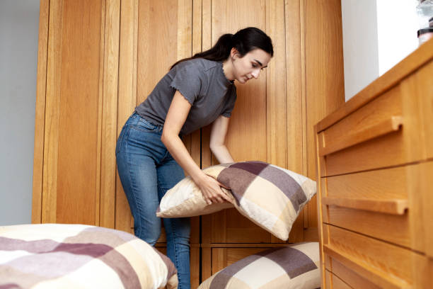 istock Young woman making the bed at home 1268685889