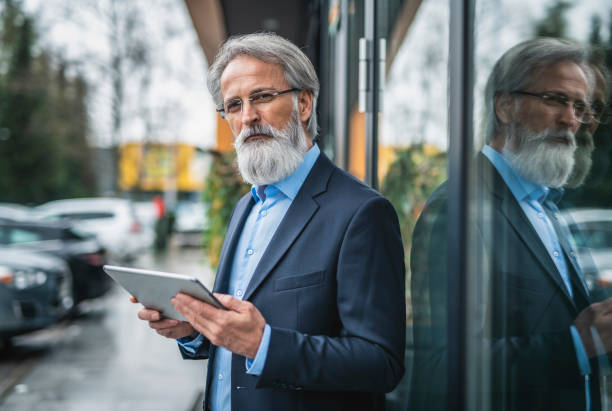 istock Caucasian senior businessman using a digital tablet outside his hotel 1268686205