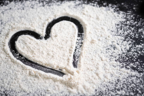 istock Hand drawn heart on table sprinkled with confectionery flour 1268687828