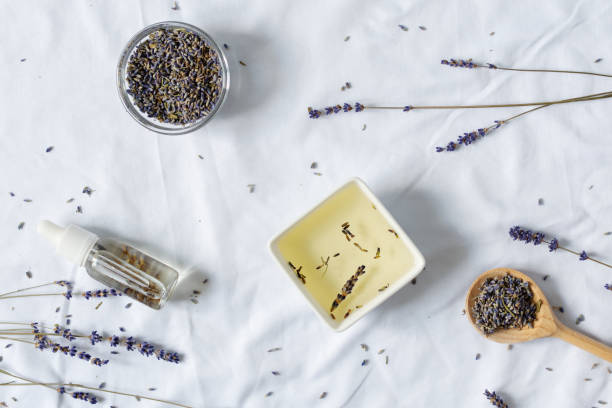 istock Aromatic essential and massage oil with lavender flowers on white background. 1268689040