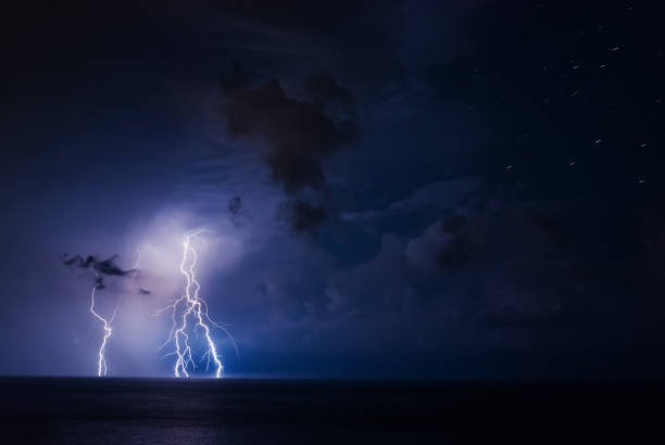 istock Thunderstorm over the sea with dark clouds and multiple lightning bolts in the lower left corner 1268689959