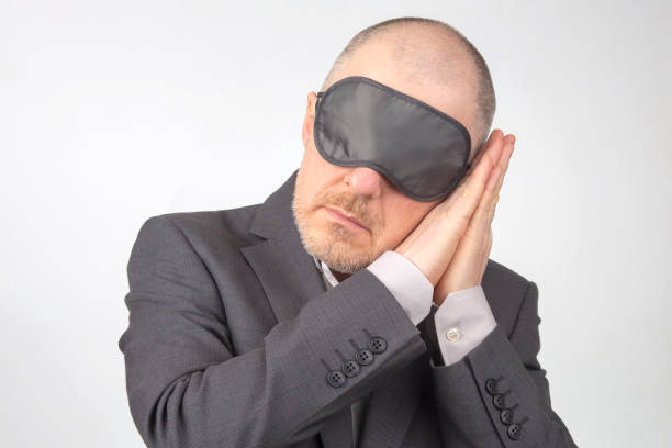 istock business man in blindfold for sleeping with arms raised for rest on a white background 1268696692