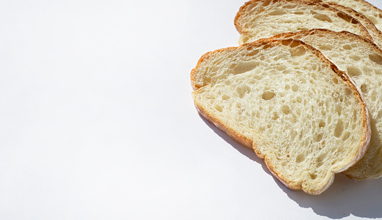 Pieces of wheat bread on a white background. Copy space for text.