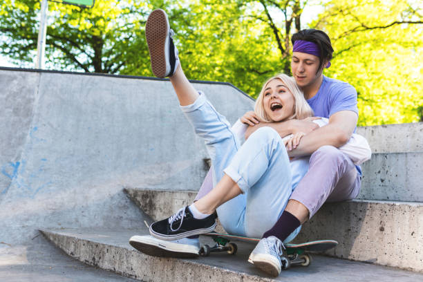 glückliches und liebevolles teenager-paar in einem skatepark - teenage couple stock-fotos und bilder