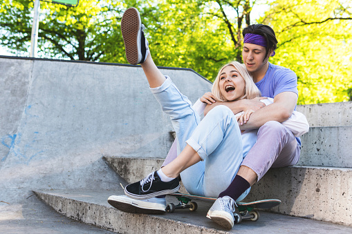 Portrait of happy and loving teenage couple in a skatepark