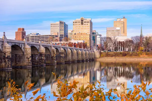 Harrisburg, Pennsylvania, USA skyline on the Susquehanna River with fall foliage.