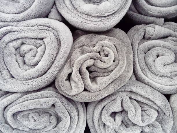 istock Gray blankets, rolled up and lying on a shelf in a store. Scandinavian lifestyle. Interior decor elements. Warm blankets 1268703621