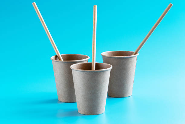 istock Three eco friendly disposable brown craft paper cups with paper straws on blue background. Plastic free and zero waste concept. 1268704444