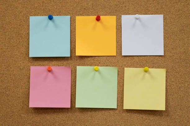 istock Colorful reminder sticky notes push pins on cork board. empty free space. 1268708947
