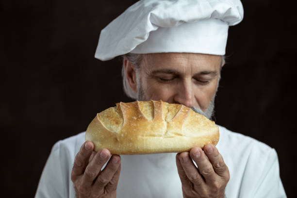 istock Portrait of a handsome male baker smelling fresh bread 1268710679
