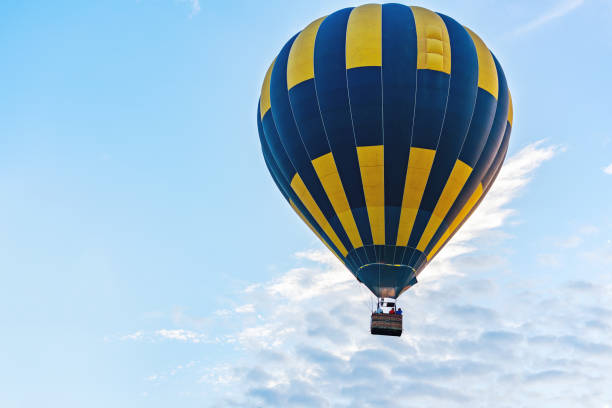 mongolfiera multicolore su sfondo cielo nuvoloso blu - inflating balloon blowing air foto e immagini stock