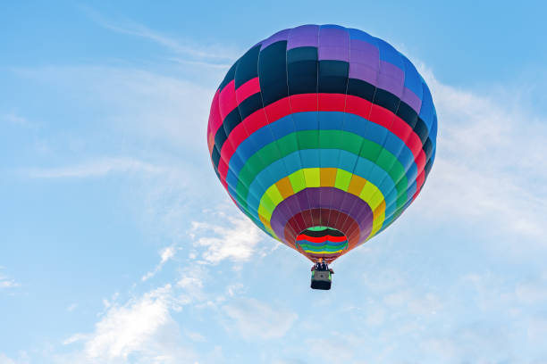 istock Multicolored hot air balloon on blue cloudy sky background 1268712067