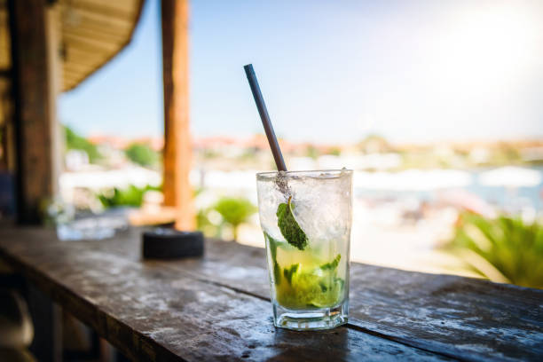Cold Mojito cocktail in a beach bar in front of the beach. Summer holiday concept. Relaxation in the summer.