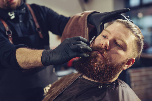 istock Barber shaves the beard of the client 1268716498