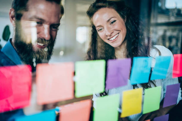 istock Businesspeople brainstorming with adhesive notes in a meeting 1268720824