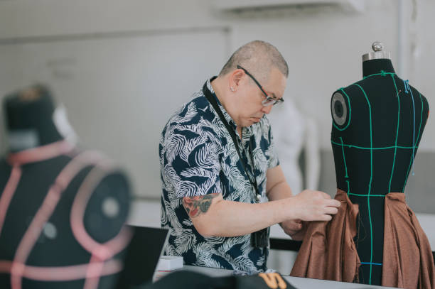 college fashion design lecturer showing his students on the fashion design clothing pin on mannequin college fashion design lecturer showing his students on the fashion design clothing pin on mannequin atelier fashion stock pictures, royalty-free photos & images