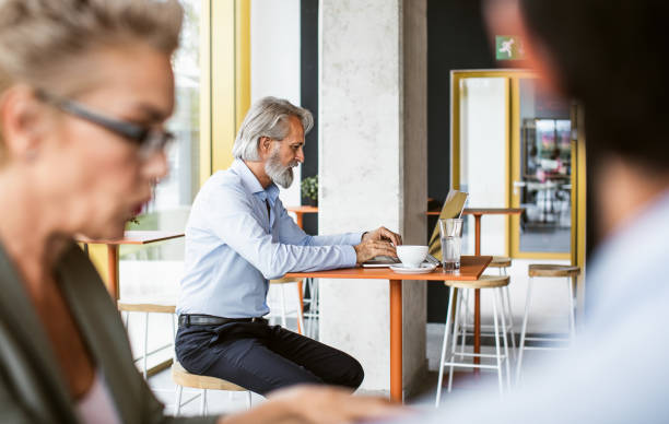 istock Businessman working on laptop in cafeteria 1268721593