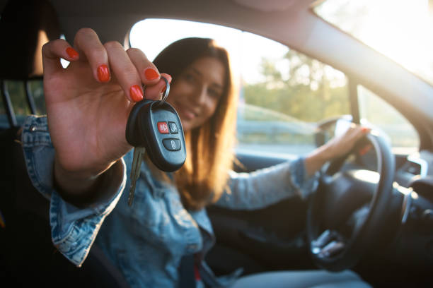 Happy girl with car keys sits in her new car. Buy, win a car. Contented woman Happy girl with car keys sits in her new car. Buy, win a car. Contented woman car key photos stock pictures, royalty-free photos & images