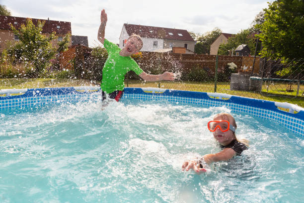 istock Boy and girl playing in pool 1268724696