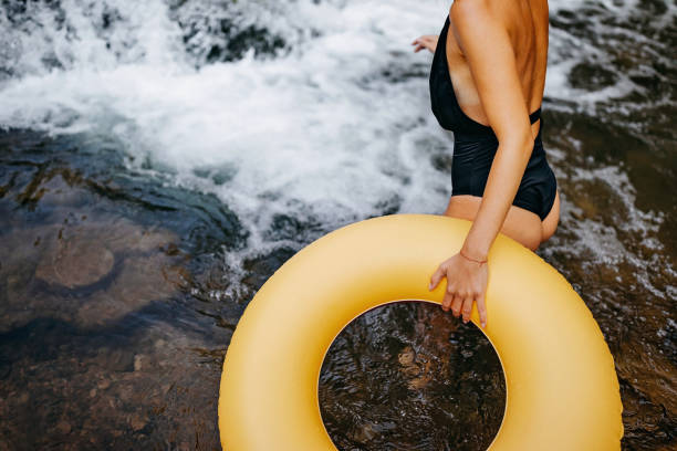istock Women holding swimming float near river 1268724781