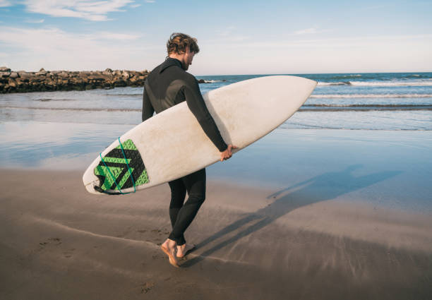 istock Surfer entering into the water with his surfboard. 1268733197