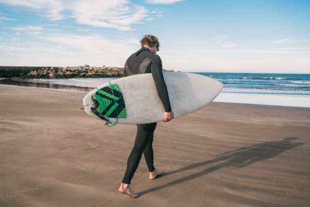 istock Surfer standing in the ocean with his surfboard. 1268733221