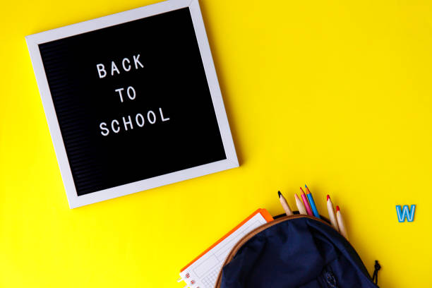 istock Words Back to school on yellow background. Education, back to school concept, top view, flat lay 1268733496