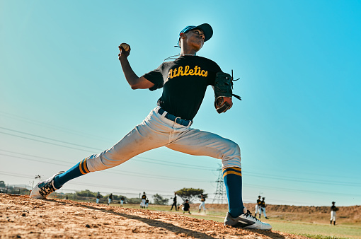 Baseball pitcher, match and athlete throw or pitch ball in a game or training with a softball team. Sports, fitness and professional man or person in a competition with teamwork in a stadium
