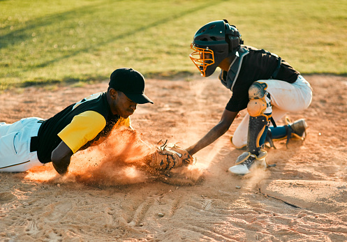 Shot of a baseball player sliding to the base during a baseball game
