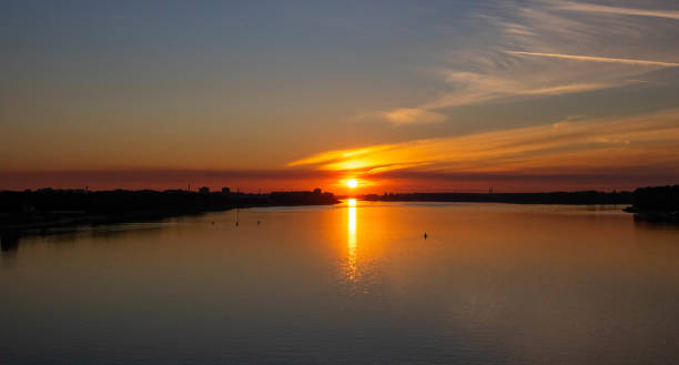 istock Orange sunset over the river on a summer evening 1268744134