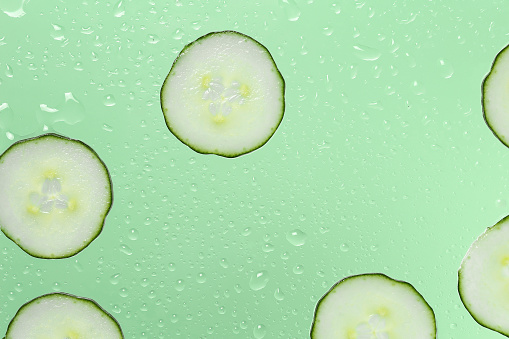 cucumber slices on glass with water drops