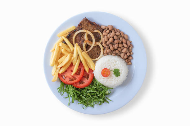 istock Brazilian food dish. Beans, rice, meat, chips, cabbage, tomatoes, onions. Executive dish. Dish done. Top view. Copy space. Isolated on white background. 1268759519
