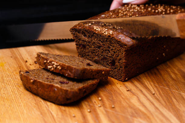 黒い背景に自家製の黒パン。セクションの写真。 - brown bread bread cutting board full length ストックフォトと画像